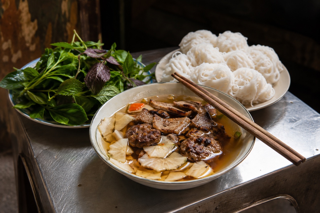 Suất bún chả Hà Nội: chén nước chấm loãng có chả miếng, chả viên, đu đủ ngâm giấm, dĩa bún rối và rổ rau