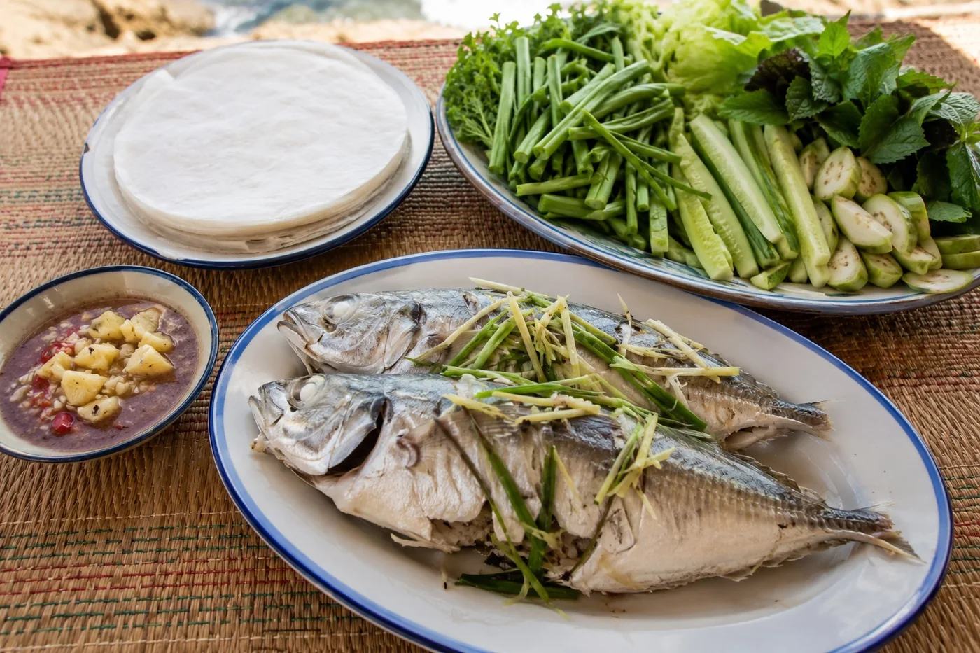 Cá nục hấp còn nguyên con, cuốn bánh tráng với rau muống chẻ, dưa leo, chấm mắm nêm.