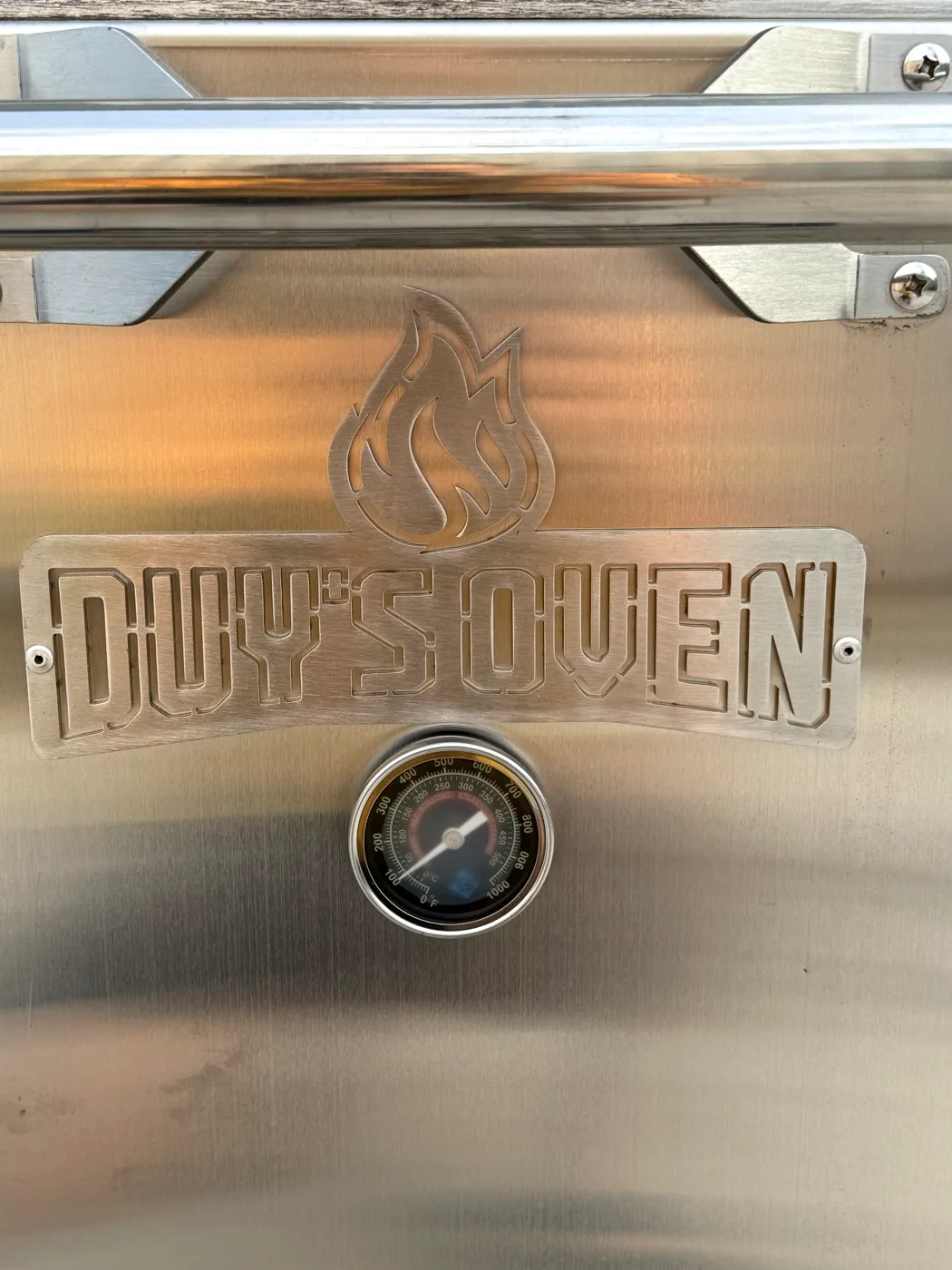 Đồng hồ nhiệt và logo Duy's Oven trên cửa lò